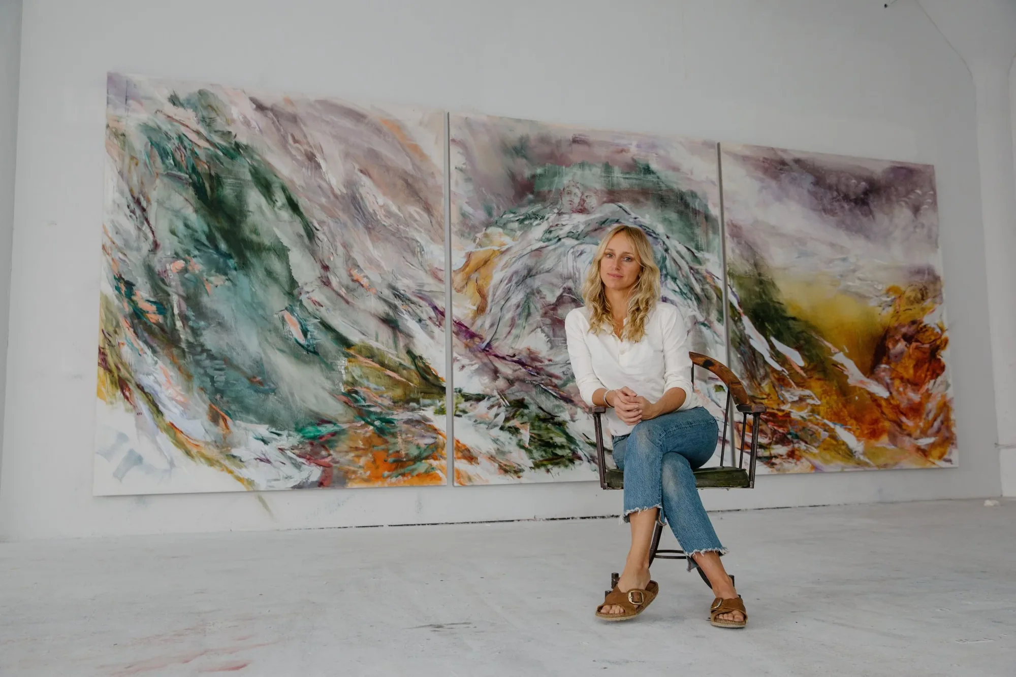 Kylie Manning seated in front of a large painting