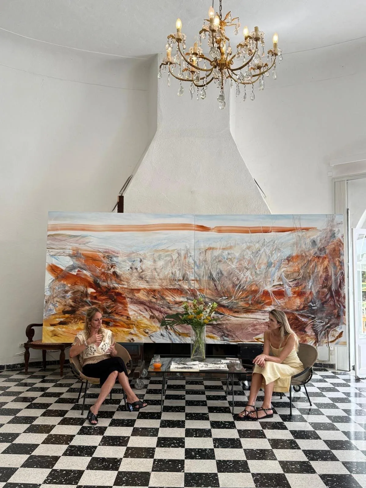 Kylie Manning and Maria-Theresia Mathisen seated in front of a large painting at Castel Caramel